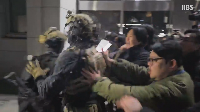 지난해 12월 3일 밤 국회에 진입하려는 계엄군과 시민과 대치하는 모습.