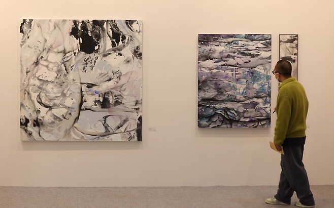 11일 서울 강남구 세텍에서 열린 ‘아트 오앤오’에 전시된 작품 9점이 완판된 황원해 작가의 작품을 한 관람객이 바라보고 있다. 한주형 기자