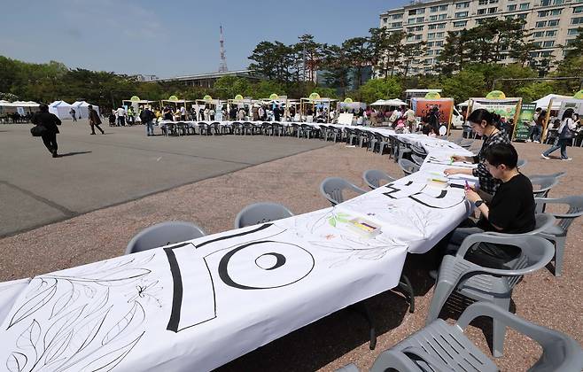 4월 22일 지구의 날을 기념해 '우리의 힘, 우리의 지구'란 주제로 20일 서울 여의도공원에서 열린 '2025 지구의 날 기념행사'에서 참가자들이 대형 그림 그리기를 하고 있다.