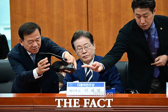 이날 이재명 예비후보는 의도치 않은 말 실수로 지적받기 싫다며 마이크를 꺼달라고 요청했다. 사진은 서유석 금융투자협회장(왼쪽) 등 관계자가 마이크를 치우는 모습.