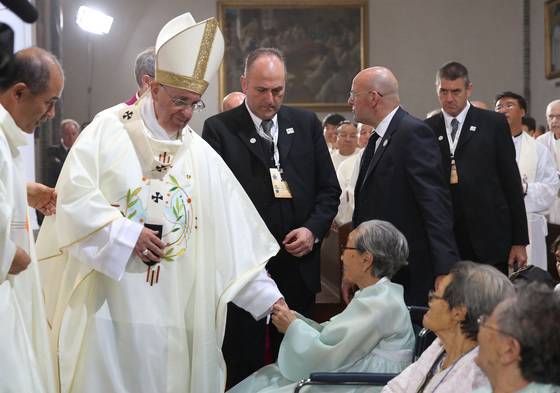 프란치스코 교황이 서울 중구 명동성당에서 열린 '평화와 화해를 위한 미사' 집전을 위해 입장하면서 위안부 출신 할머니들을 만나 위로 하고 있다. 중앙포토