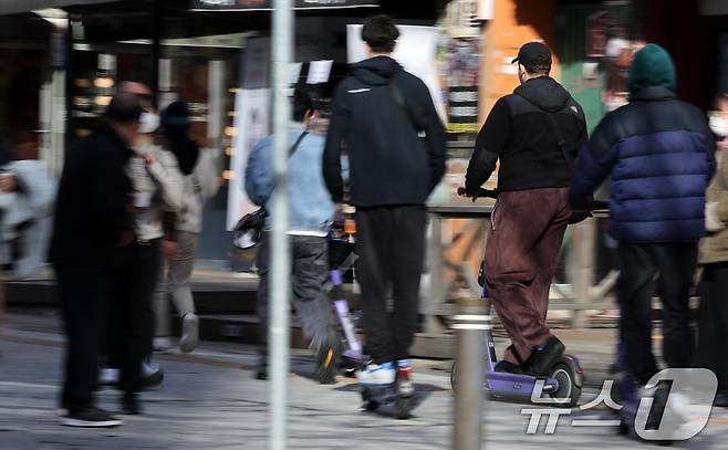 19일 서울 시내에서 외국인 관광객들이 전동킥보드를 타고 있다. 19일 업계에 따르면 경찰청은 늦어도 내년 1월까지 유관기관 단체와 협의해 전동킥보드 등 개인형 이동장치(PM) 전용 운전면허 신설과 관련한 합리적 안을 도출할 계획이라고 전했다. 현재 도로교통법상 공유 전동킥보드는 제2종 원동기장치자전거 면허 또는 그 이상(제2종 소형·보통면허, 제1종 보통면허 등)의 운전면허 소지자만 이용할 수 있다. 면허 취득 방식으로는 세 가지가 거론된다. 학과시험(필기시험)만 치르거나, 학과와 기능시험(실습시험)을 함께 치르거나, 온라인 교육만 이수하는 방안 등이 있다. 2024.11.19/뉴스1 ⓒ News1 이동해 기자