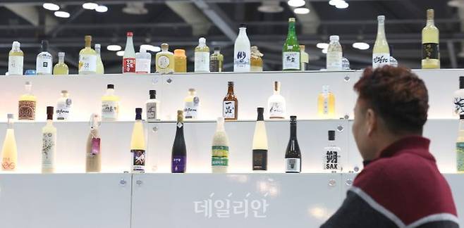 '우리쌀·우리술 K-라이스페스타'에서 한 관람객이 전시된 우리쌀로 만든 전통주를 살펴보고 있다. ⓒ뉴시스