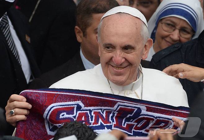 프란치스코 교황이 2013년 7월 25일 브라질 리우데자네이루의 한 교회를 방문한 자리에서 자신이 팬인 아르헨티나 축구팀 '산 로렌소'의 스카프를 들고 있다. 교황은 21일 선종했다. ⓒ AFP=뉴스1 ⓒ News1 최종일 선임기자