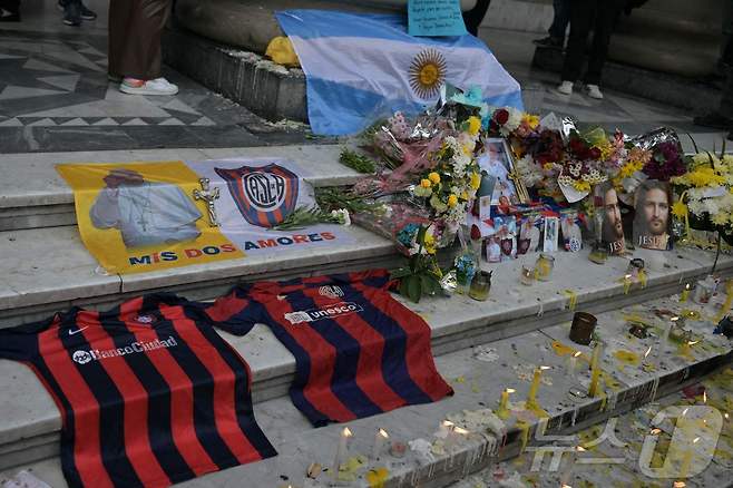 프란치스코 교황을 애도하기 위해 축구 클럽 '산 로렌소'의 유니폼이 22일(현지시간) 부에노스아이레스 대성당 밖에 놓여 있다. 교황은 21일 선종했다. 2025.04.22 ⓒ AFP=뉴스1 ⓒ News1 최종일 선임기자