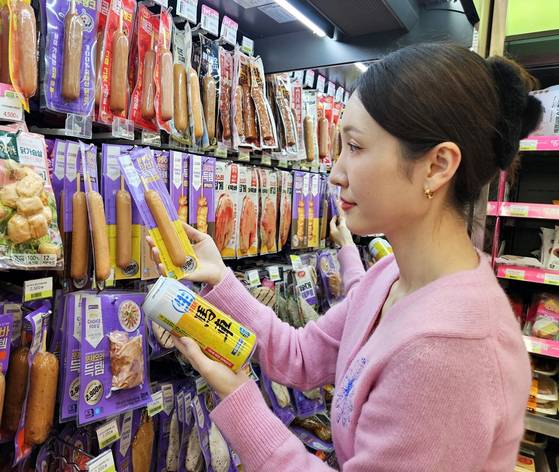 CU의 초저가 PB인 '득템 시리즈' 핫바(990원)와 맥주(1900원)를 고르고 있는 방문객. 사진 BGF리테일