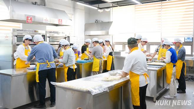 충남교육청 직원들이 23일 김지철 교육감과 함께 제빵사로 변신해 취약계층에 전달할 단팥빵을 만들고 있다.