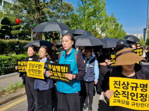 인천의 교원 단체가 24일 검은 우산을 들고 도보행진 시위를 벌이고 있다. 정성식기자