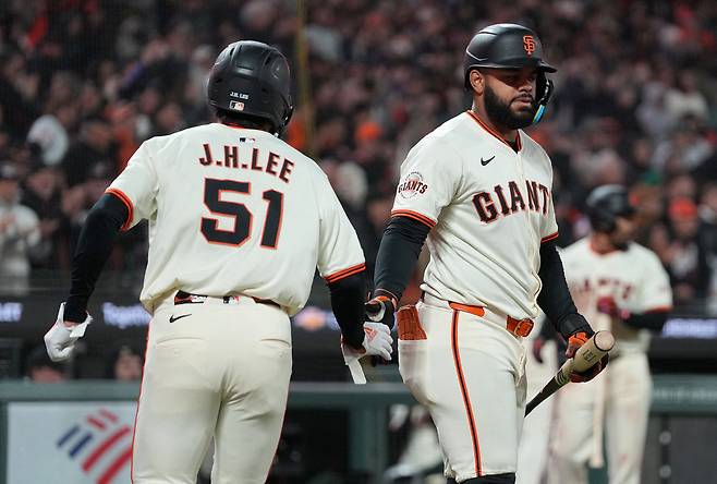 6회말 우전안타를 치고 나간 이정후가 윌머 플로레스의 적시타 때 홈을 밟은 뒤 엘리엇 라모스의 환영을 받고 있다. AFP연합뉴스