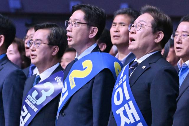 26일 오후 광주 서구 김대중컨벤션센터에서 열린 더불어민주당 21대 대통령선거 후보자 선출을 위한 호남권 합동연설회에서 김동연(왼쪽부터), 김경수, 이재명 경선 후보가 애국가를 부르고 있다. 2025.4.26/뉴스1