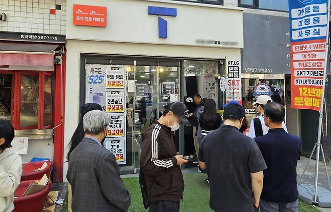 지난 26일 서울 시내 한 SKT 대리점에서 고객들이 유심을 교체하기 위해 줄을 서 기다리고 있다. 연합뉴스