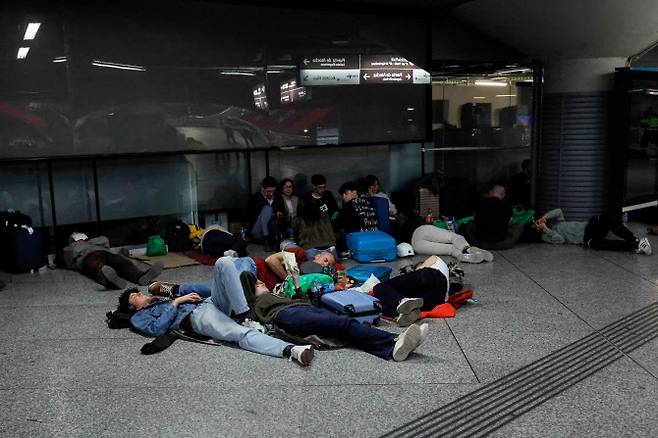 28일 스페인 마드리드 아토차 기차역에서 대규모 정전 사태로 발이 묶인 여행객들이 바닥에 누워 밤을 보낼 준비를 하고 있다. (사진=AFP)