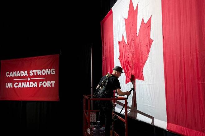 한 남성이 "캐나다는 강하다"라는 자유당 구호 앞에서 캐나다 국기를 그리고 있다. 로이터연합뉴스