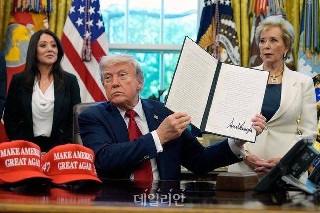 도널드 트럼프 미국 대통령이 지난 23일(현지 시간) 백악관 집무실에서 흑인대학(HBCU)에 관한 행정명령에 서명한 뒤 이를 들어 보이고 있다.ⓒ뉴시스