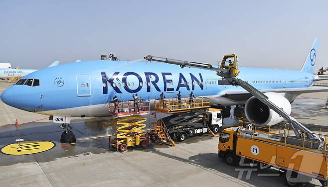 24일 오전 인천 중구 인천국제공항 대한항공 격납고에서 직원들이 봄을 맞아 항공기 동체를 세척하고 있다. 이날 세척한 항공기는 보잉 777-300ER 기종으로 대한항공의 새 도장이 적용된 기체다. (공동취재) ⓒ News1 장수영 기자