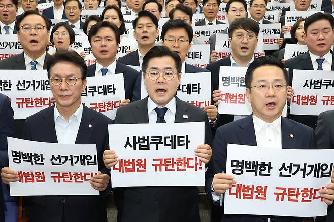 더불어민주당 21대 대선 상임 총괄선대위원장인 박찬대 당대표 직무대행 겸 원내대표와 의원들이 1일 오후 서울 여의도 국회에서 열린 긴급 의원총회에서 이재명 대통령 후보의 공직선거법 위반 혐의에 대해 대법원이 유죄 취지의 파기 환송 결정한 것에 대해 규탄 구호를 외치고 있다./뉴스1