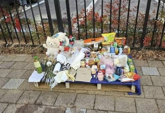 경남 사천시 사천읍의 한 아파트 앞 인도에 성탄절날 숨진 여고생을 기리는 국화와 과자와 음료수, 핫팩 등이 쌓여있다. (사진=뉴스1)