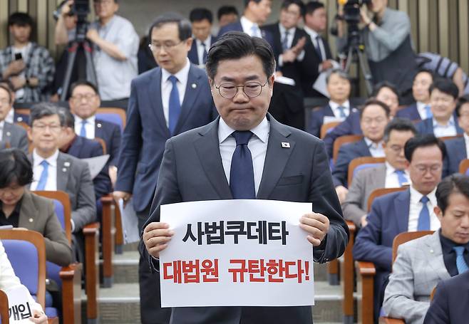 대법원이 더불어민주당 이재명 대표의 공직선거법 위반 혐의 2심 무죄판결을 파기 환송한 1일 서울 여의도 국회에서 열린 민주당 긴급의원총회에서 박찬대 원내대표가 대법원 규탄 손팻말을 들고 있다./연합뉴스