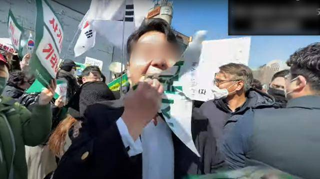 극우 유튜버가 서울 서대문구 이화여대에서 윤석열 대통령 탄핵 찬성 집회 참가자의 피켓을 빼앗아 씹어 먹는 시늉을 하고 있다. 신남성연대 유튜브 캡처