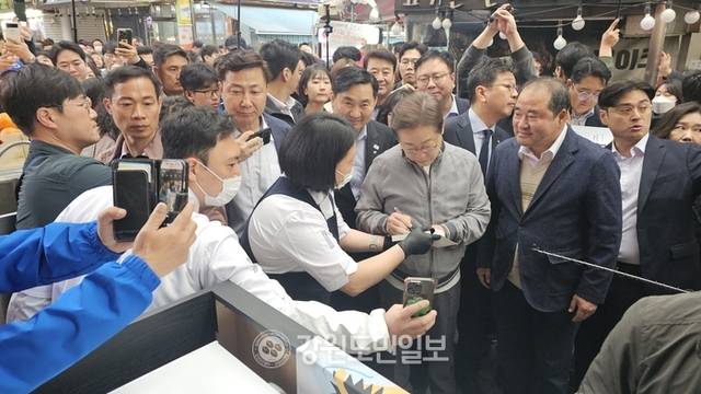 ▲ 이재명 더불어민주당 대선 후보가 3일 속초시를 방문, 자서전을 들고온 청년상인에게 사인을 해주고 있다.