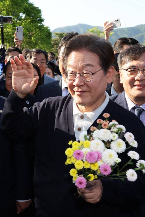 이재명 더불어민주당 대선 후보가 ‘골목골목 경청투어’ : 단양8경편‘에 나선 4일 충북 제천군 의림지를 찾아 한 지지자가 준 꽃을 들고 인사하고 있다. (사진=연합뉴스)