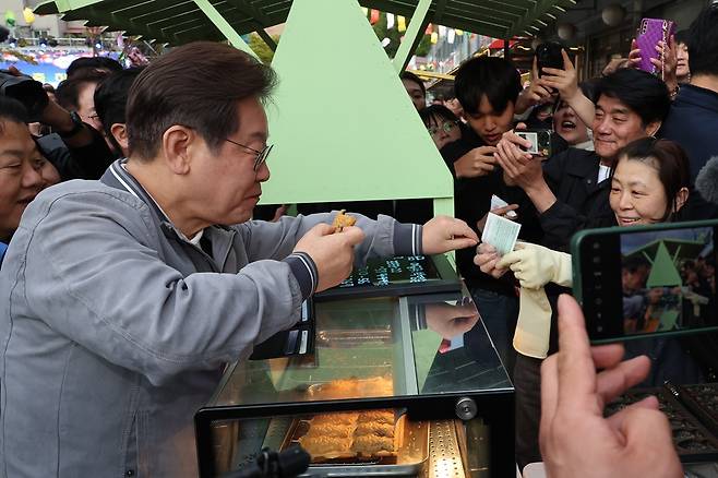 이재명 더불어민주당 대선 후보가 ‘골목골목 경청투어’ 사흘째인 지난 3일 강원도 태백시 장성동 산나물 축제장에서 지역화폐로 붕어빵을 사고 있다. 연합뉴스