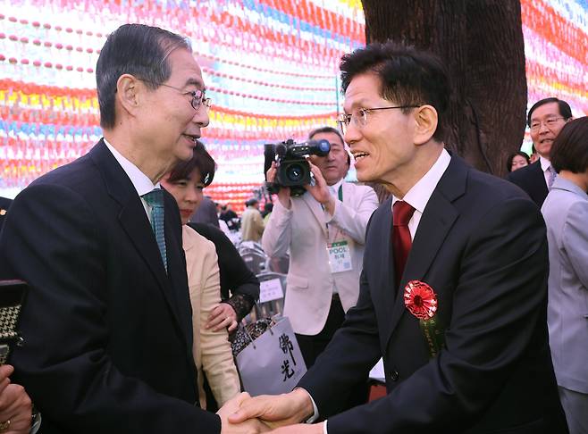 국민의힘 김문수 대선 후보(오른쪽)와 무소속 한덕수 대선 예비후보가 5일 서울 종로구 조계사에서 열린 불기 2569년 부처님오신날 봉축법요식을 마친 뒤 악수하고 있다. /연합뉴스