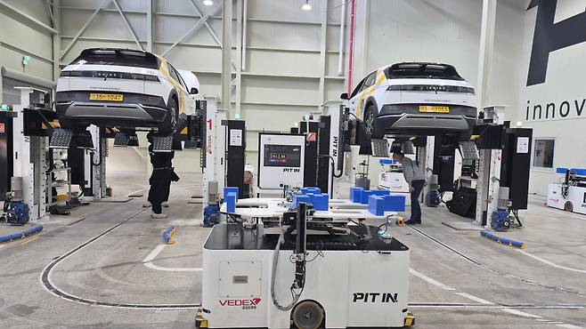 4월 29일 경기 안양시의 피트인 스테이션에서 아이오닉5 택시의 배터리팩 교체 작업이 진행되고 있다. 바닥에 조성된 트랙에서 피트인이 개발한 자율주행 로봇이 배터리팩 교체 작업을 위해 움직이고 있다. / 진상훈 기자