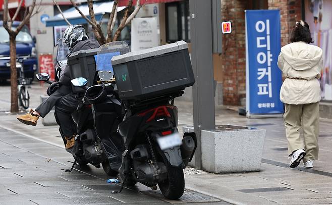 지난 3월18일 서울 시내에서 대기 중인 배달 기사 모습. 연합뉴스