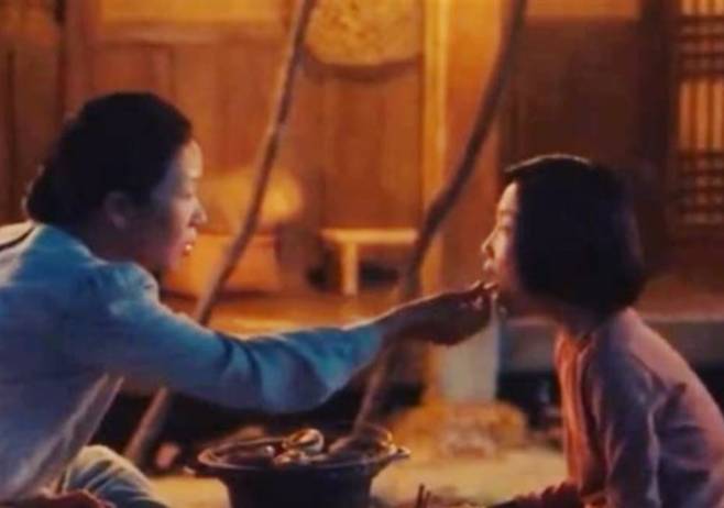 애순이 엄마가 애순이에게 구운 조개를 먹여주고 있다. /드라마 <폭싹 속았수다> 영상캡처