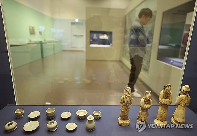 조선시대 죽은 이를 위한 나무 인형과 작은 그릇 (서울=연합뉴스) 이재희 기자 = 4월 30일 서울 종로구 대한민국역사박물관에서 열린 광복 80주년 특별전 '기록, 메모리 오브 유'(Memory of you)에서 관계자가 전시를 둘러보고 있다.