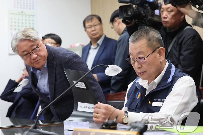 박점곤 서울시버스노동조합 위원장이 29일 서울 영등포구 서울지방노동위원회에서 열린 사측 서울시버스운송조합과의 임금·단체협약(임단협) 막판 협상에 앞서 조정신청서 서류를 살펴보고 있다. 왼쪽은 김정환 서울시버스운송조합 이사장. (공동취재) 2025.4.29/뉴스1 ⓒ News1 이승배 기자