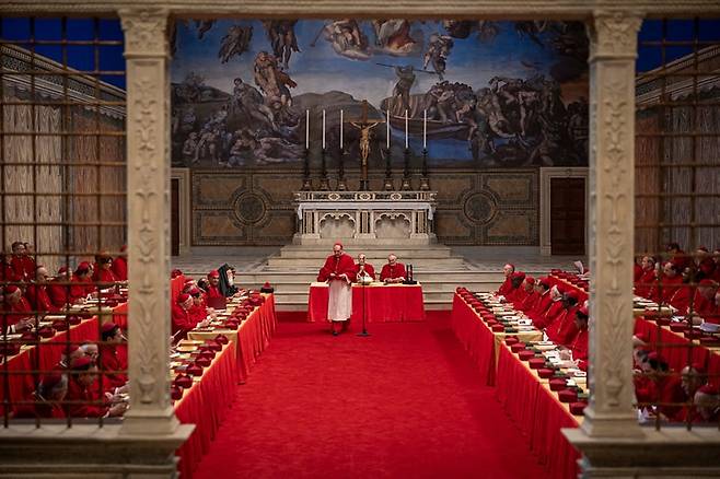 영화 '콘클라베'의 한 장면. 추기경단의 자리 뒷벽에 미켈란젤로의 대작 '최후의 심판'이 보인다. 천장에는 미켈란젤로의 '천지창조'가 그려져 있는 성당이다. /디스테이션