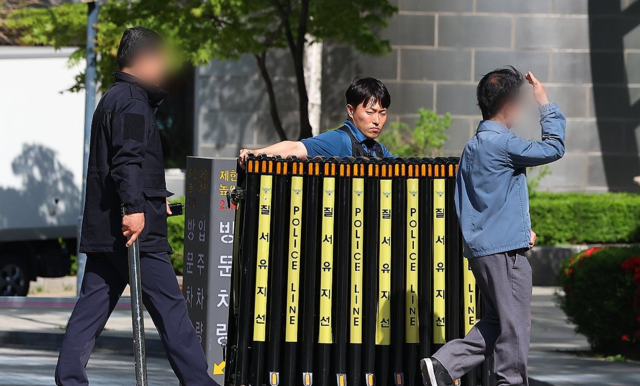 지난달 30일 서울 서초구 아크로비스타 앞에서 경찰이 검찰의 윤석열 전 대통령 사저 압수수색을 끝낸 뒤 바리케이드를 치우고 있다. 연합뉴스