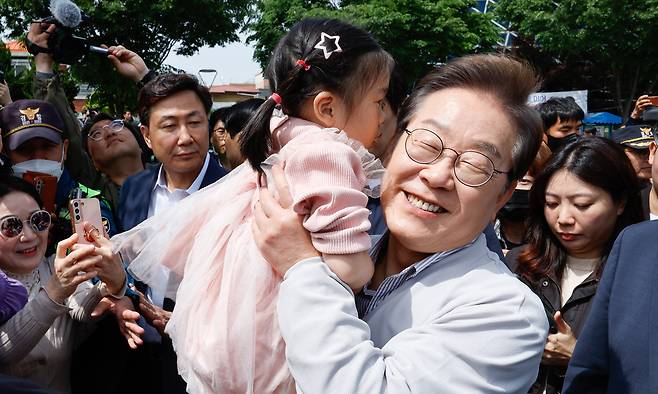 이재명 더불어민주당 대통령 후보가 2차 골목골목 경청투어 마지막 날인 7일 오후 전북 전주시 풍남문 앞에서 한 어린이를 안아들고 있다. 전주=뉴스1