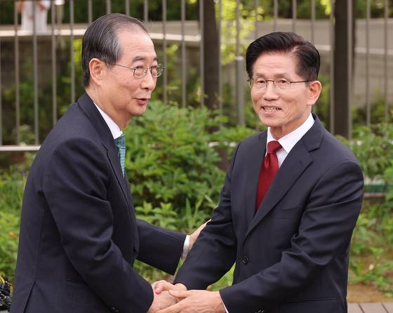 김문수 국민의힘 대선 후보와 무소속 한덕수 대선 예비후보가 지난 8일 서울 국회 사랑재에 위치한 커피숍에서 악수하고 있는 모습. 단일화 관련 문제를 논의했으나 별소득 없이 끝났다. 〈사진=연합뉴스〉