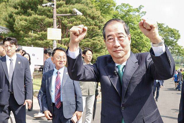 한덕수 무소속 대선 예비후보가 8일 경북 구미시 박정희 전 대통령 생가 추모관을 방문한 자리에서 지지자들에게 두 손을 들어 보이며 인사하고 있다. 한 후보는 “국가와 국민을 생각한다면 김문수 국민의힘 대선 후보가 단일화 약속을 지키라고 얘기하겠다”고 말했다. 연합뉴스