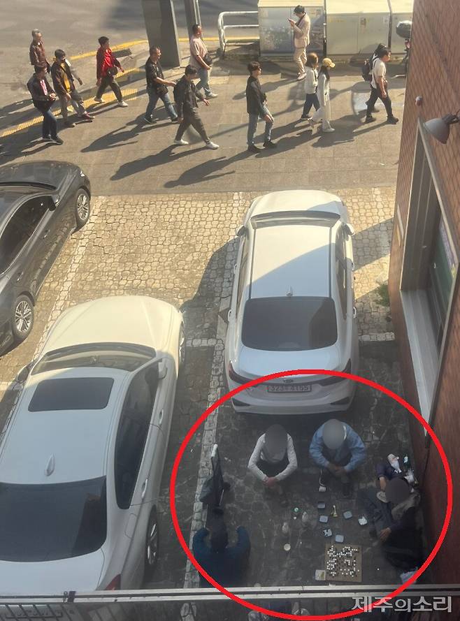 탐라문화광장 바로 옆 상가 주차장. 지나가는 관광객들을 아랑곳하지 않고 주취자들이 술을 마시며 바둑을 두고 있다. 사진=독자 제공 ⓒ제주의소리