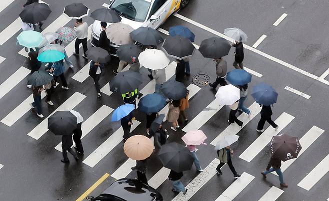 전국 대부분 지역에 비가 내린 9일 오후 서울 종로구 종각역 인근에서 우산을 쓴 시민들이 발걸음을 옮기고 있다. /뉴스1
