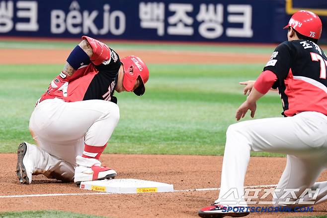 3루에서 슬라이딩 후 허리를 만지고 있는 KIA 최형우.