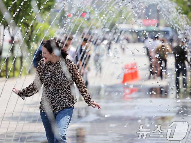 대체로 맑고 포근한 '초여름 날씨'를 보인 12일 오후 서울 광화문광장 분수터널에서 외국인 관광객들이 더위를 식히고 있다. 2025.5.12/뉴스1 ⓒ News1 황기선 기자