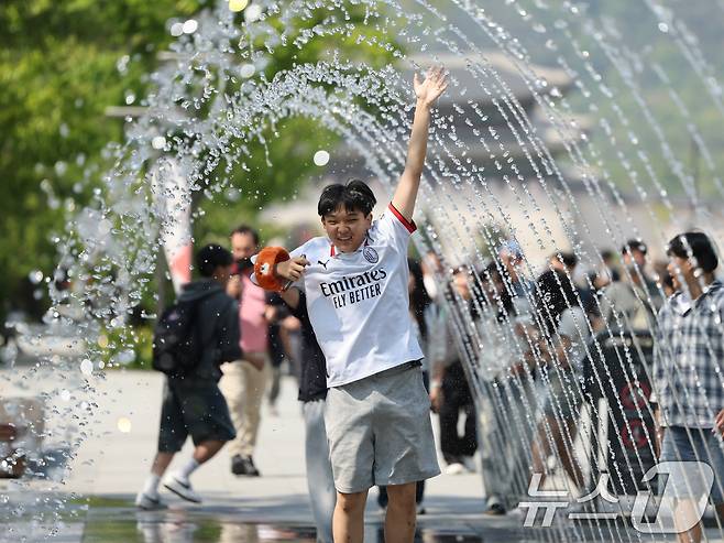 대체로 맑고 포근한 '초여름 날씨'를 보인 12일 오후 서울 광화문광장 분수터널에서 시민들이 더위를 식히고 있다. 2025.5.12/뉴스1 ⓒ News1 황기선 기자