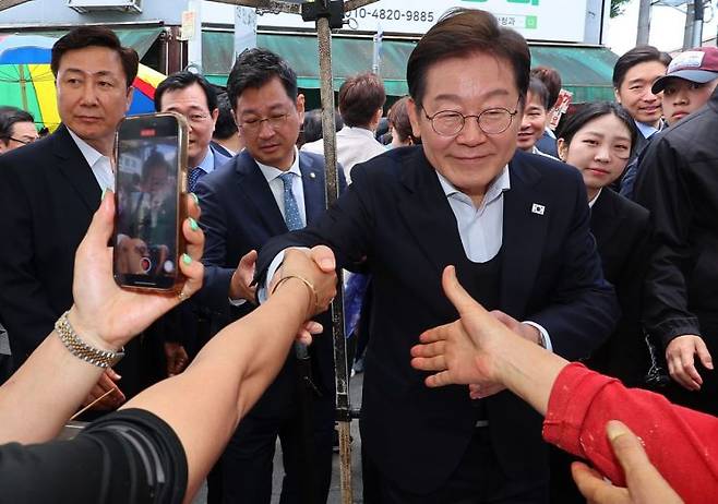 영남 신라벨트 골목골목 경청투어에 나선 더불어민주당 이재명 대선 후보가 지난 10일 경남 함안군 가야전통시장을 찾아 상인들과 인사하고 있다. 연합뉴스