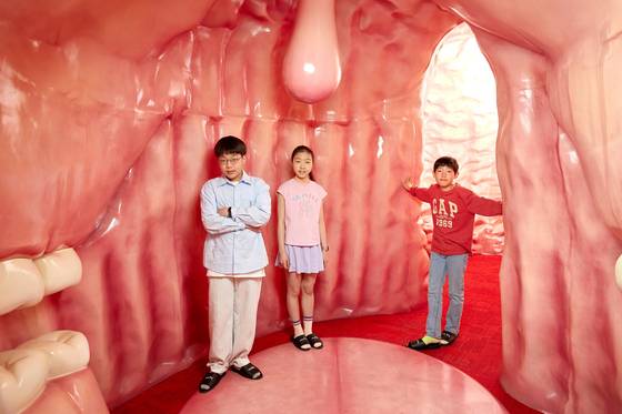 박준후 학생기자·임서희 학생모델·김산하(왼쪽부터) 학생기자가 입과 위, 장을 재현해 놓은 방에 들어가 유산균이 어떤 역할을 하는지 체험했다.