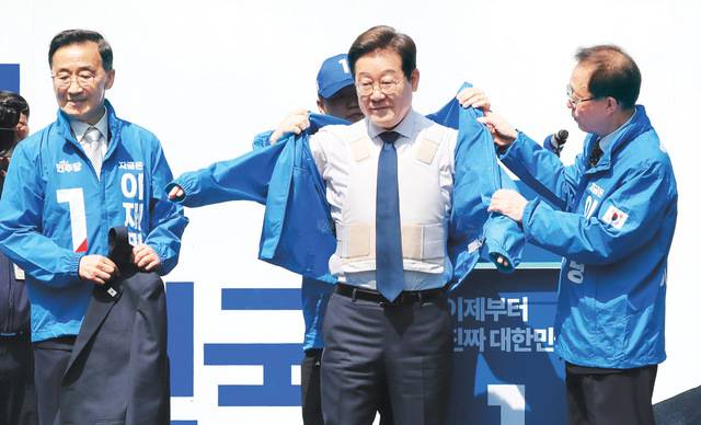 이재명 더불어민주당 대선 후보가 제21대 대통령 선거 공식 선거운동 첫날인 12일 서울 청계광장에서 열린 대선 출정식 ‘빛의 혁명’ 유세 도중 흰색 방탄복을 착용한 채 파란 선거운동복을 입고 있다. 이병주 기자