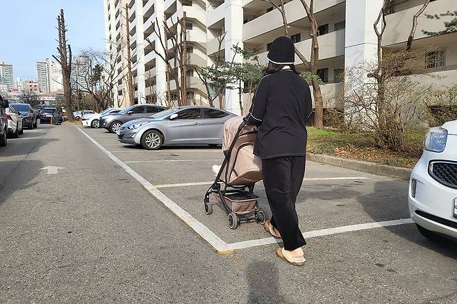 서울의 한 아파트 단지에서 한 엄마가 유모차를 끌고 걸어가고 있다.