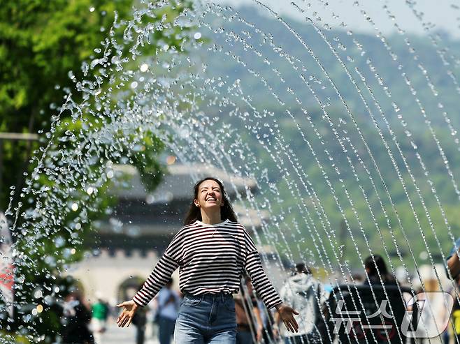 대체로 맑고 포근한 '초여름 날씨'를 보인 12일 오후 서울 광화문광장 분수터널에서 외국인 관광객들이 더위를 식히고 있다. 2025.5.12/뉴스1 ⓒ News1 황기선 기자
