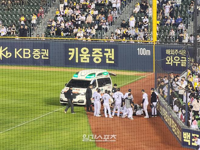 홍창기가 13일 잠실 키움 히어로즈전 9회 초 파울 타구 포구를 시도하다가 동료와 충돌, 왼쪽 무릎 부상을 당했다. LG 선수들이 구급차 이송을 준비하는 홍창기를 지켜보고 있다. IS포토