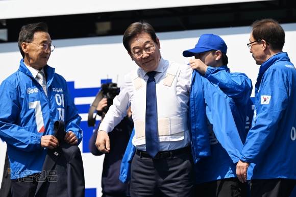 파란 선거운동복 안 흰 방검복 - 이재명(왼쪽 두 번째) 더불어민주당 대선 후보가 12일 서울 종로구 청계광장에서 열린 중앙선거대책위원회 출정식에서 방검복 위에 파란색 선거 운동복을 입고 있다. 홍윤기 기자