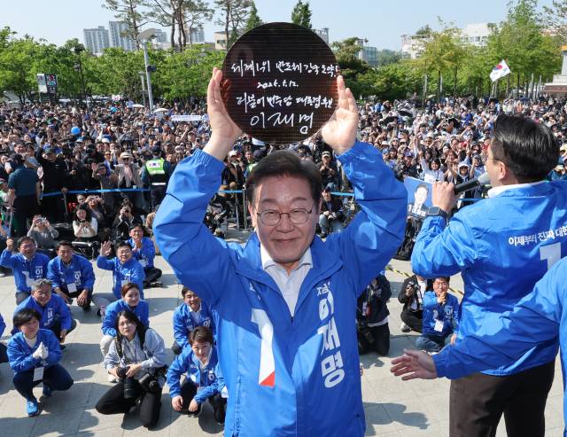 이재명 더불어민주당 후보가 6·3 대선 선거운동 첫날인 12일 경기 화성시 동탄 센트럴파크 음악분수중앙광장 유세장에서 ‘세계1위 반도체 강국 도약!’이라고 쓰고 서명한 반도체 웨이퍼를 들어보이고 있다. 공동취재단